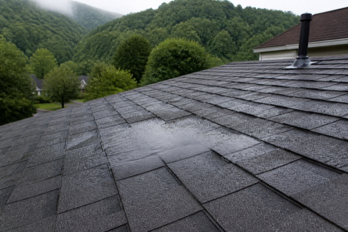 Rainwater collecting on roof shingles before waterproofing repair